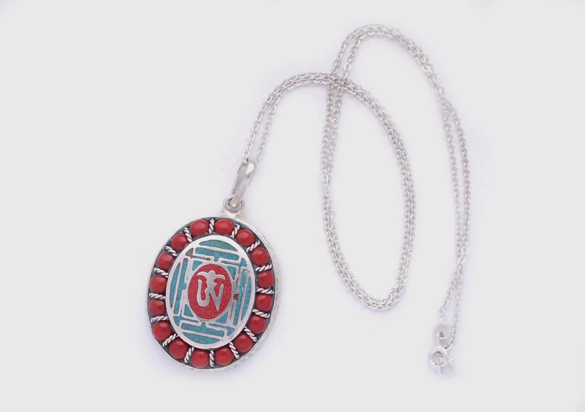 Coral Inlaid Buddha Eyes and Tibetan Om Painted White Metal Pendant