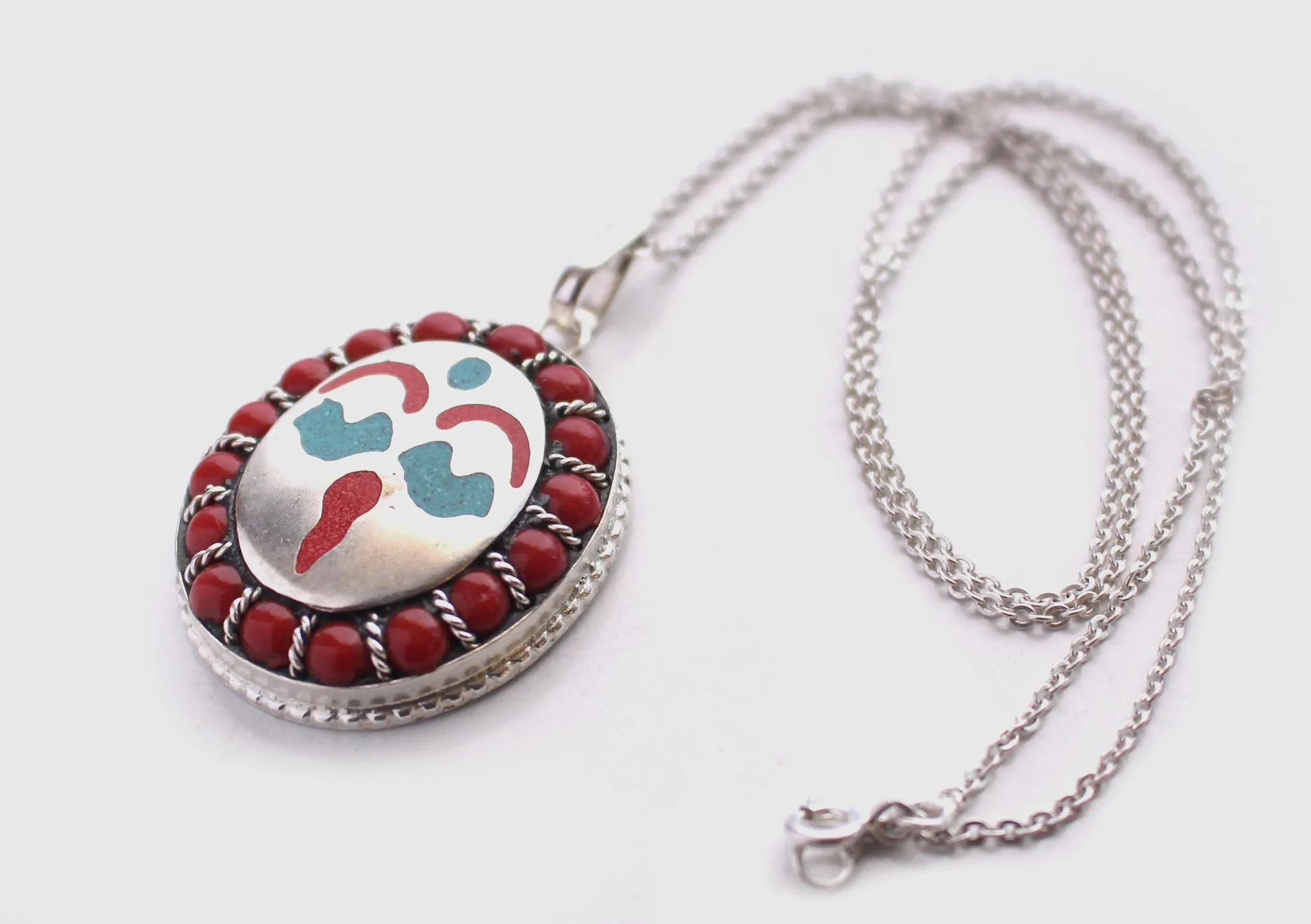 Coral Inlaid Buddha Eyes and Tibetan Om Painted White Metal Pendant