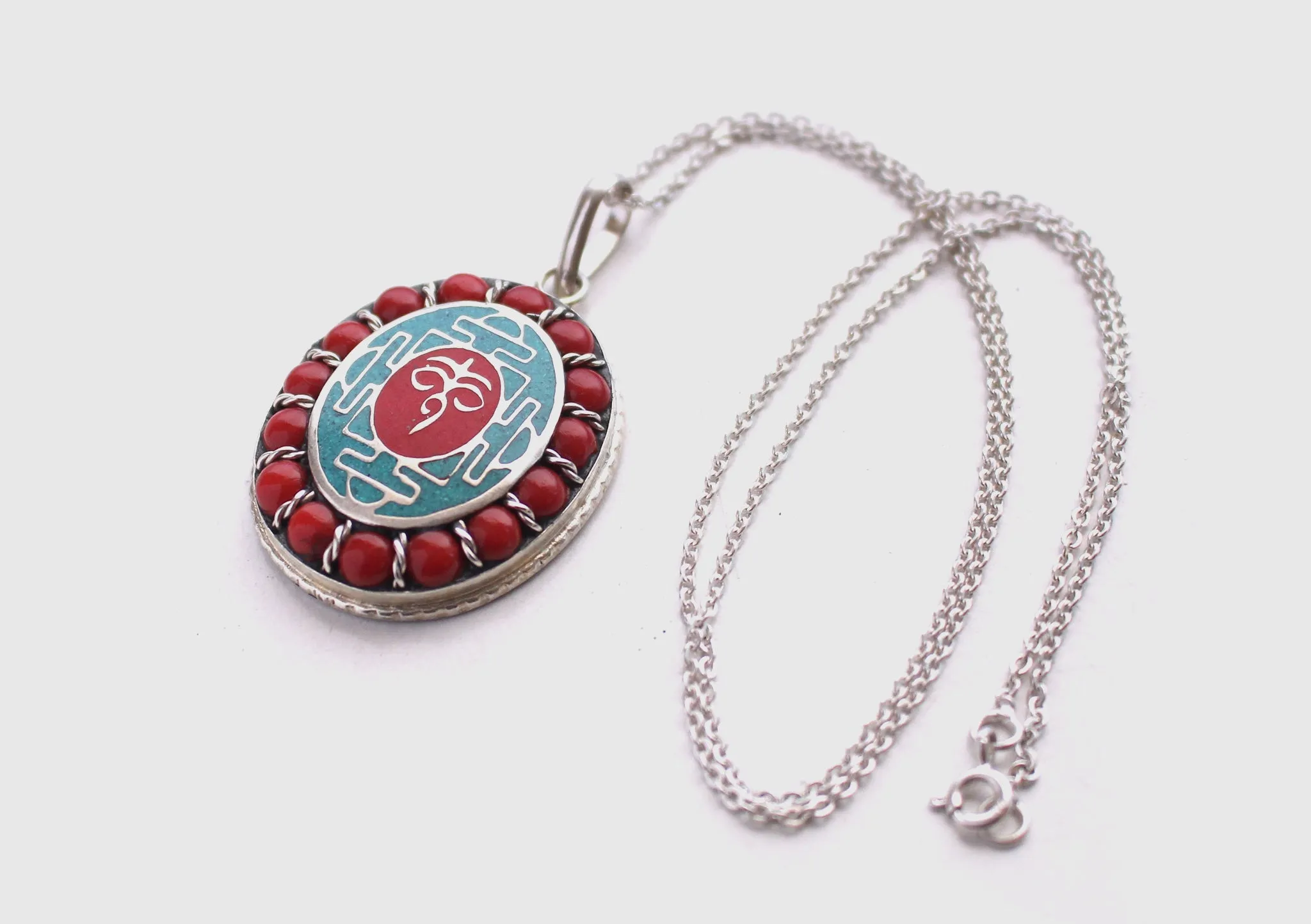 Coral Inlaid Buddha Eyes and Tibetan Om Painted White Metal Pendant