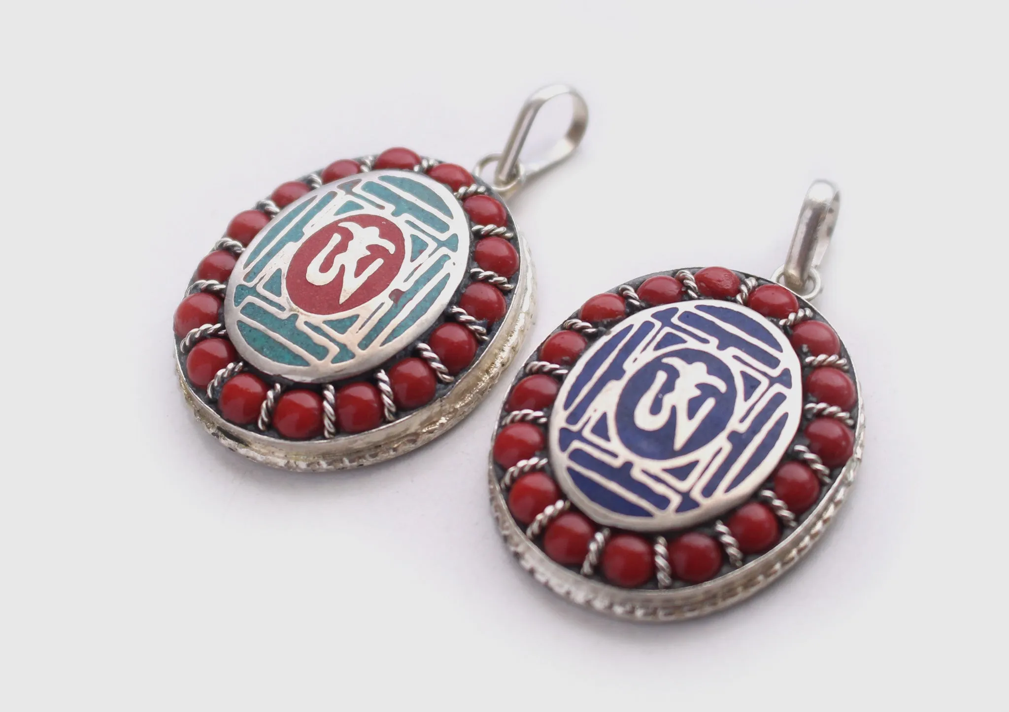 Coral Inlaid Buddha Eyes and Tibetan Om Painted White Metal Pendant